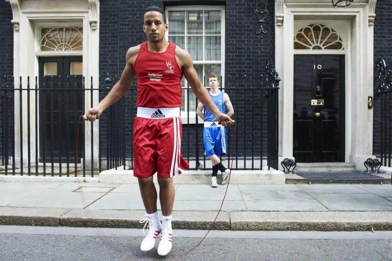 Atleta con tuta da boxe rossa salta alla corda davanti al numero 10 di Downing Street a Londra.