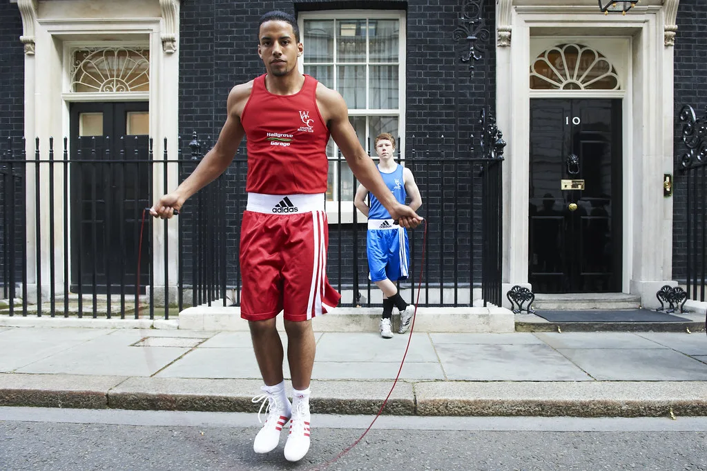 Atleta con tuta da boxe rossa salta alla corda davanti al numero 10 di Downing Street a Londra.