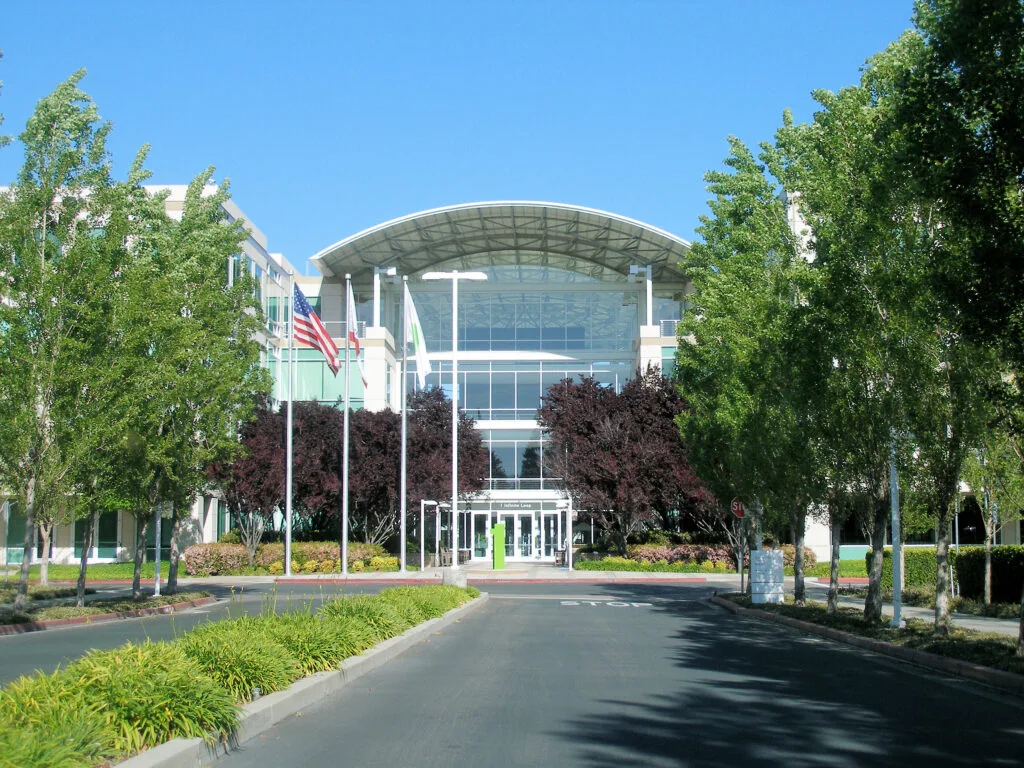Edificio moderno con cupola in vetro, bandiera americana, alberi e paesaggio curato.