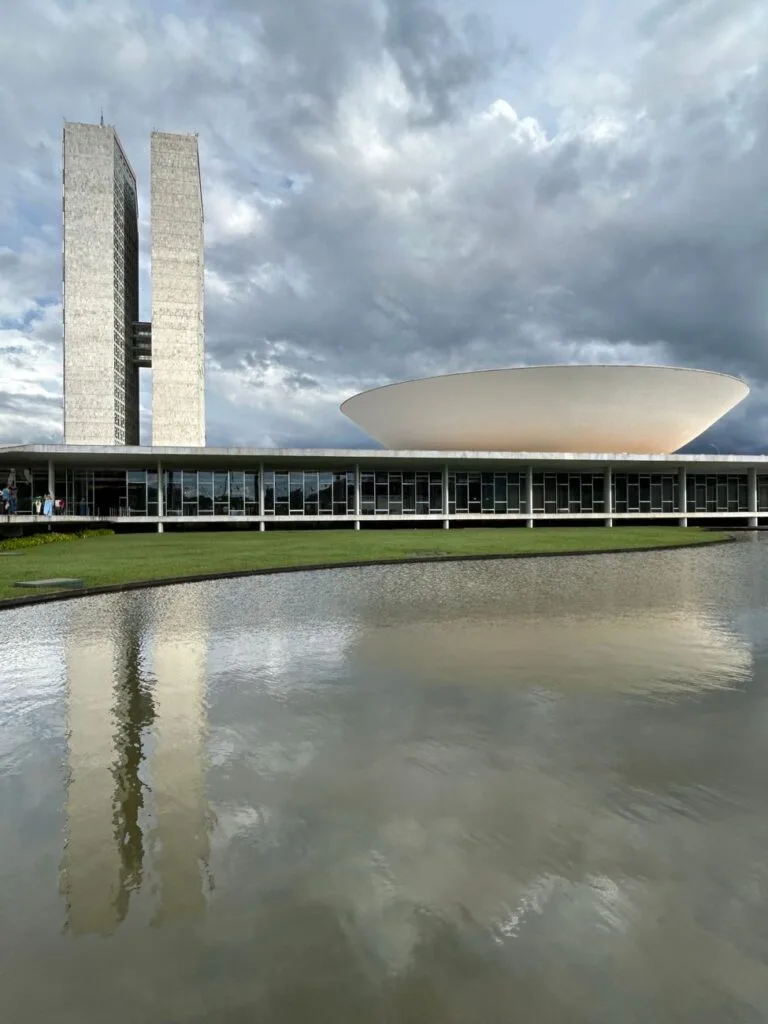 Due torri gemelle di cemento bianco del Congresso brasiliano si riflettono nell'acqua sottostante.