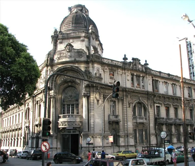 Palazzo storico con cupola in stile belle époque nel centro urbano, circondato da traffico e edifici moderni.