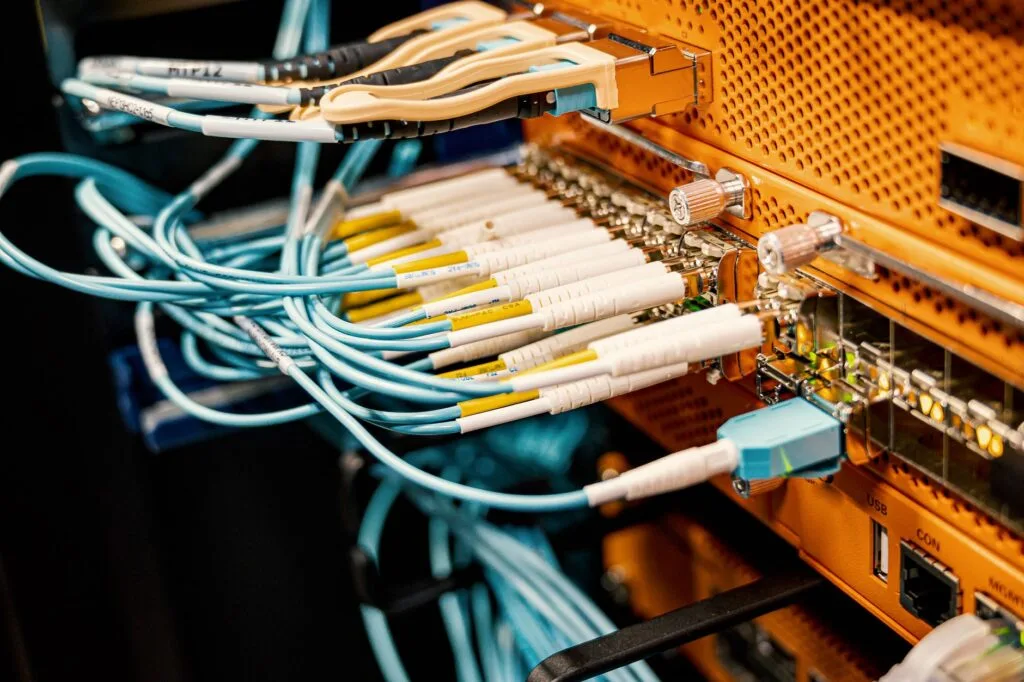 Cavi di rete blu e bianchi collegati a un pannello di gestione in un'infrastruttura di data center.