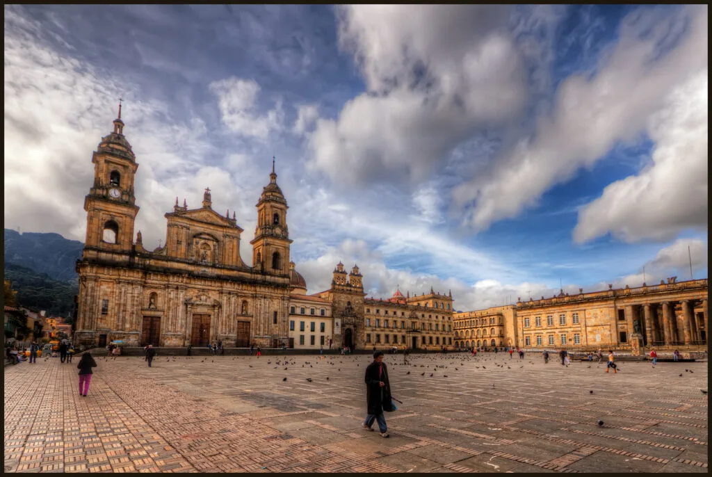 Piazza principale di Bogotá con cattedrale coloniale, edifici storici in pietra e persone sulla pavimentazione.