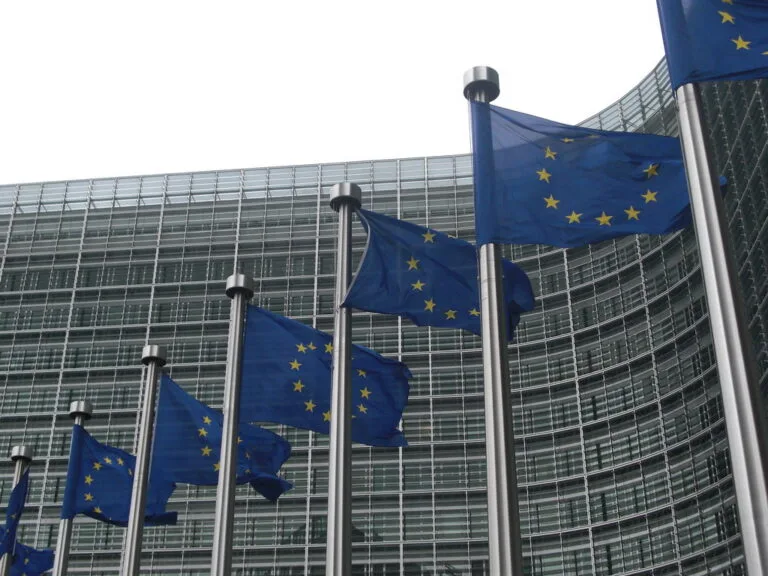 Bandiere dell'Unione Europea con le stelle gialle sventolano davanti alla sede della Commissione europea a Bruxelles.