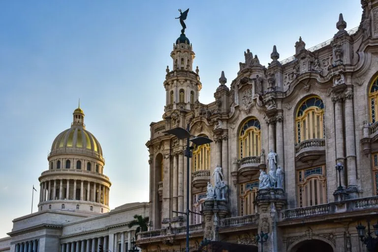 Capitolio Nazionale e Grande Teatro dell'Avana con cupole dorate e facciate barocche contro cielo azzurro.
