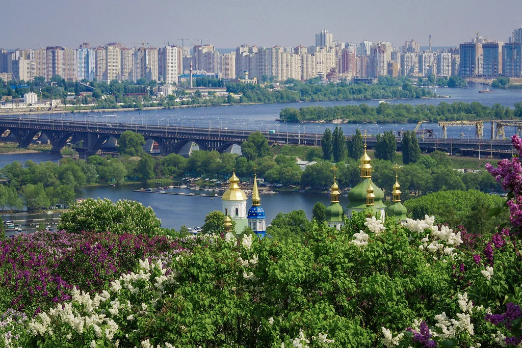 Veduta panoramica di Kiev con il fiume Dnepr, chiese ortodosse dalle cupole dorate e la skyline della città sullo sfondo.