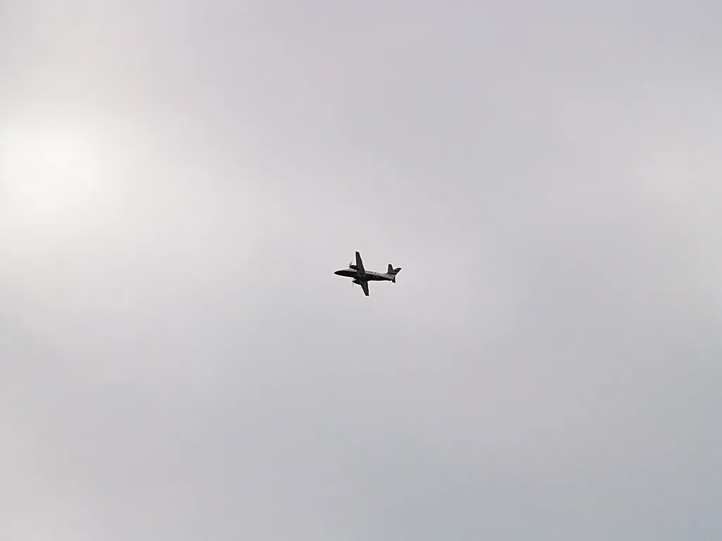 Aereo da trasporto militare in volo contro un cielo nuvoloso.
