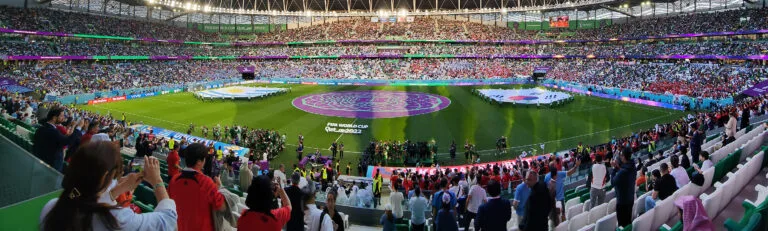 Stadio gremito di spettatori durante la cerimonia inaugurale di una competizione calcistica internazionale.