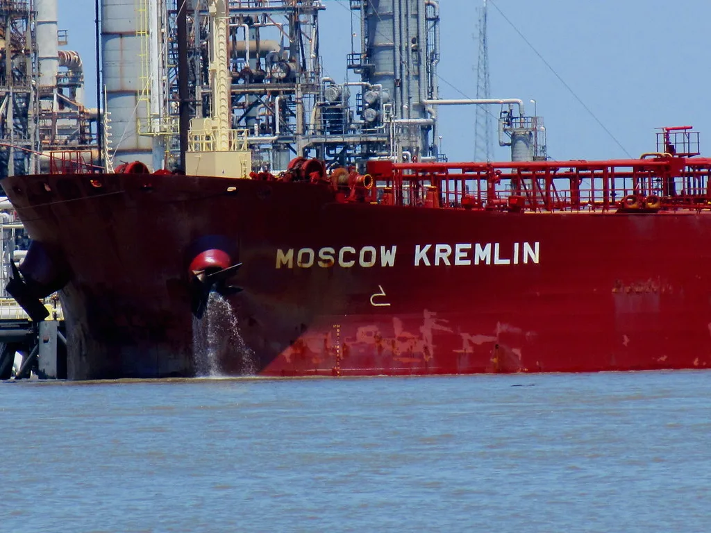 Petroliera rossa con scritta Moscow Kremlin ormeggiata in porto presso strutture industriali.