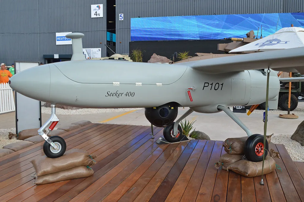 Drone Seeker 400 grigio esposto in uno stabilimento di difesa sudafricano, con carrello di atterraggio retrattile.