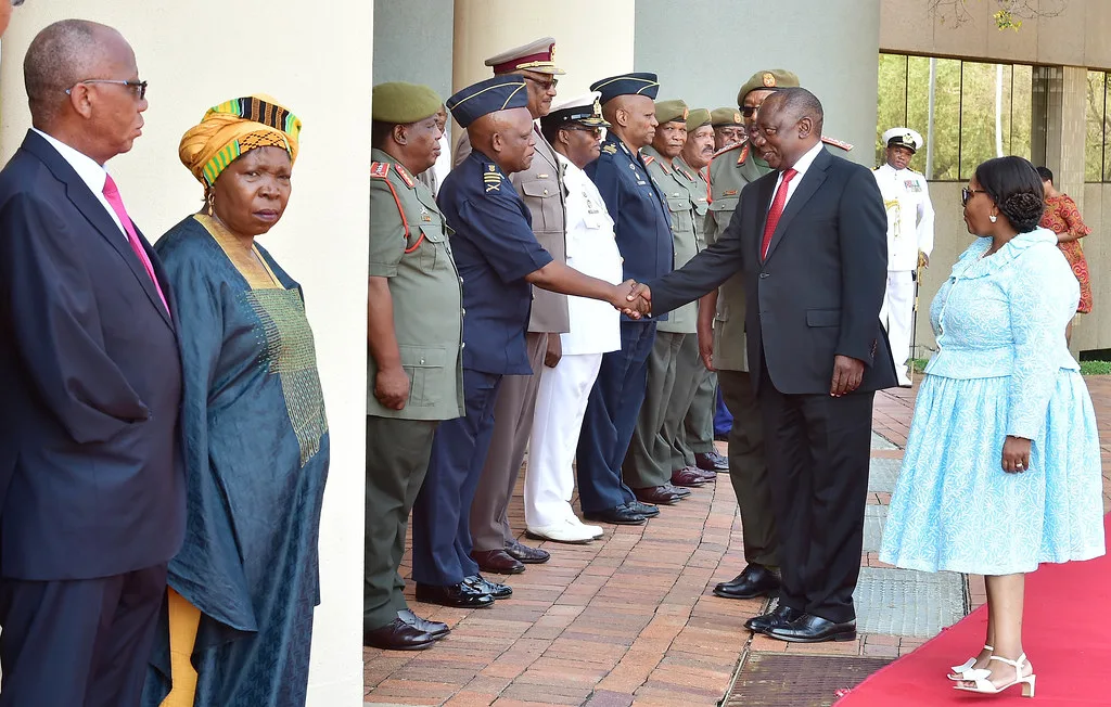 Ufficiali militari in uniforme stringono la mano a un dignitario durante una cerimonia ufficiale.