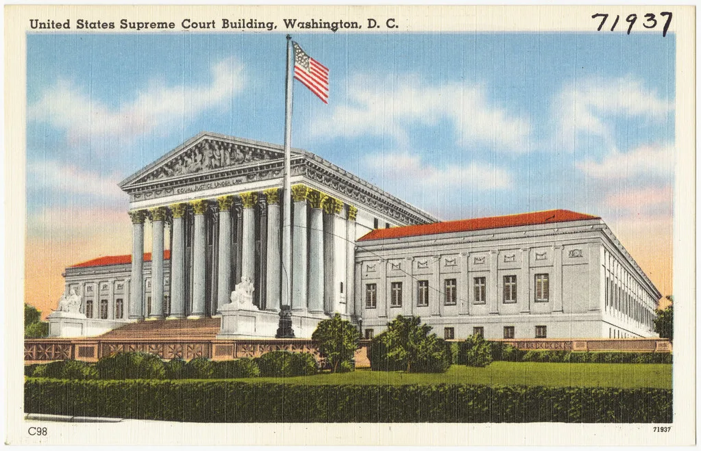 Edificio della Corte Suprema degli Stati Uniti a Washington con colonne neoclassiche, bandiera americana e tetto rosso.